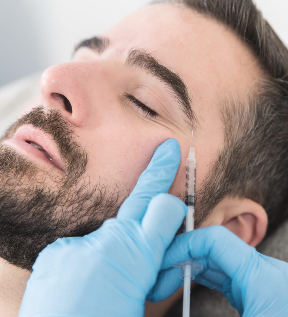 Portrait of man at clinic doing face fillers, injection procedure.